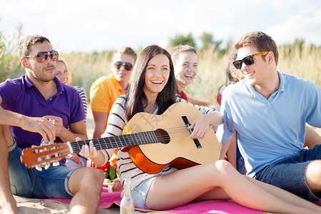 暑假,假期,音乐,快乐的人的群快乐的朋友海滩上弹吉他图片
