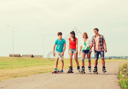 假期,爱友谊的群微笑的青少带着溜冰鞋滑板户外骑马背景图片