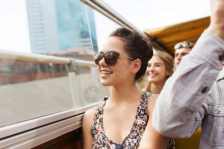 旅游,暑假,观光人的快乐的少女戴着太阳镜,群朋友乘旅游巴士旅行图片
