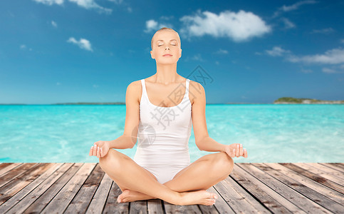 人,健康,健康冥想女人穿着内衣冥想瑜伽莲花姿势木地板上的海洋蓝天背景背景图片