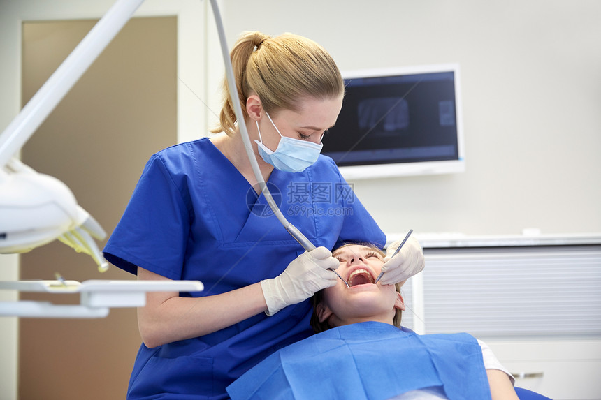 人,医学,口腔科保健快乐的女牙医用牙科工具检查病人女孩的牙齿牙科诊所办公室图片