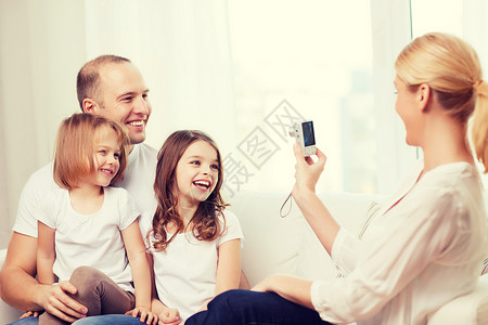 家庭,孩子,摄影家庭微笑快乐的母亲家里给父亲两个女儿拍照图片