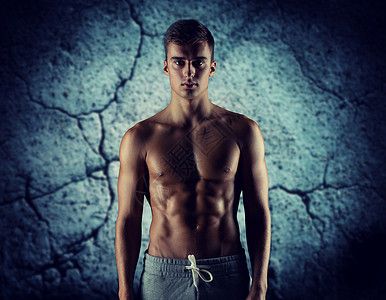 运动,健美,力量人的轻人裸露的肌肉躯干站混凝土墙壁背景上图片
