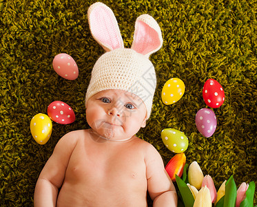 帽子中兔子三个月的婴儿躺草地地毯上,复活节兔子复活节小兔子背景