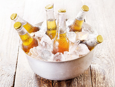冷啤酒装桶里的冷瓶啤酒,木桌上冰背景