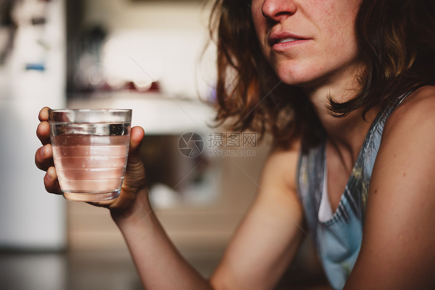 女人正家里厨房里喝杯水图片