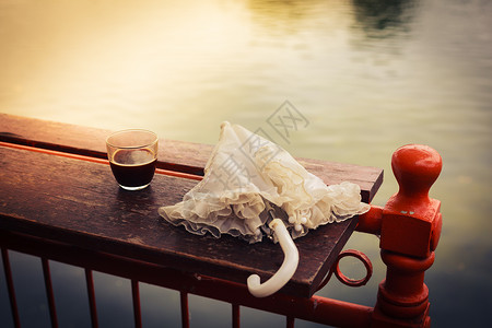 下午,杯咖啡把雨伞放湖边的木桌上天气高清图片素材