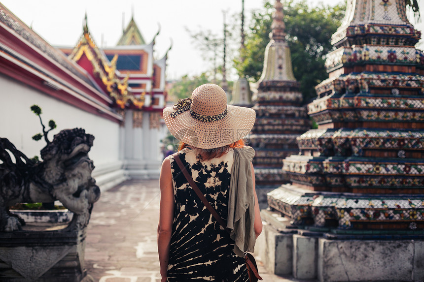 一个年轻的女人正探索座佛教寺庙图片