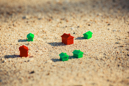 沙滩上的沙子里红色绿色的小塑料房子图片