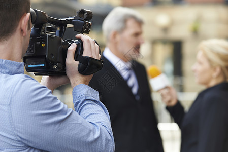 活动拍摄记者摄影师录制女记者采访商人背景