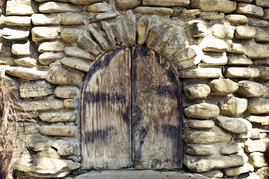 古老的拱形窗户石墙上,中世纪风格的木制百叶窗图片