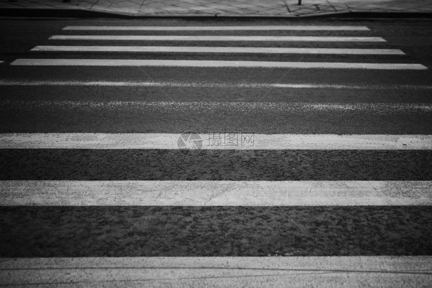 黑色沥青路上破旧的人行横道图片