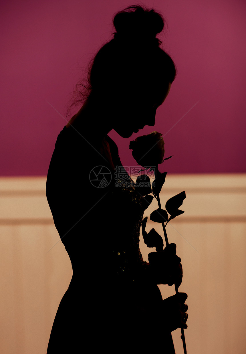 轻的女人剪影抱着玫瑰图片