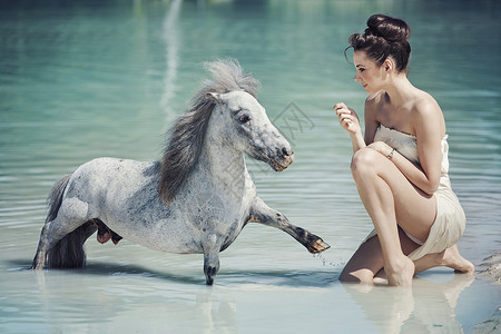 迷人的女士游泳池里玩小马高清图片