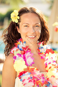 轻的微笑的女人夏威夷的鲜花花环海滩上暑假的背景图片