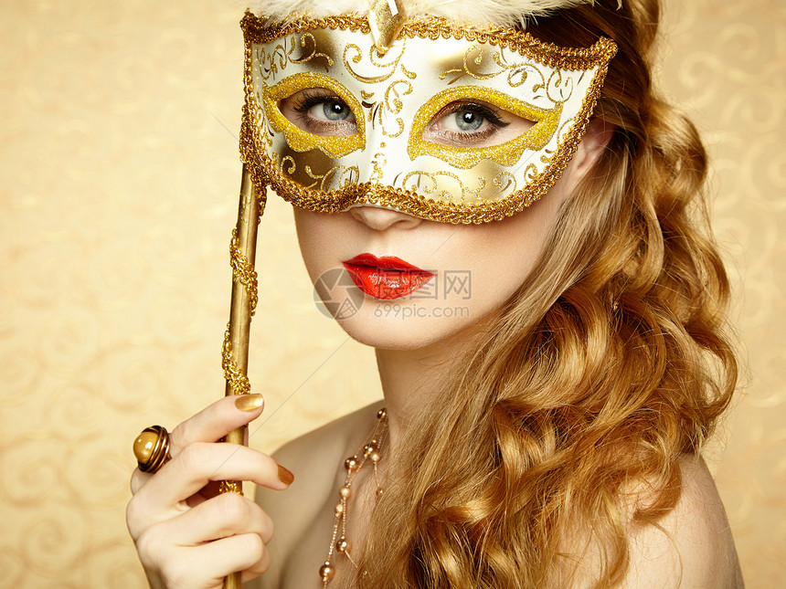 美丽的轻女人戴着神秘的金色威尼斯具时尚照片图片