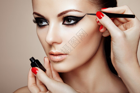 粘滞剂化妆师应用眼影漂亮的女人脸完美的妆容背景