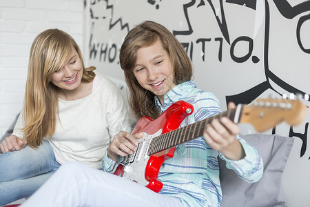 女孩家里听姐姐弹吉他高清图片