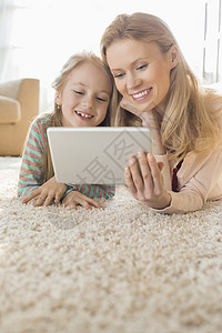 快乐的母女家里用数字平板电脑高清图片