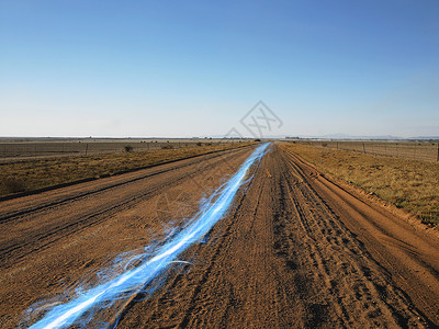 蓝色的光条纹泥土路上映衬着晴朗的天空地貌高清图片素材