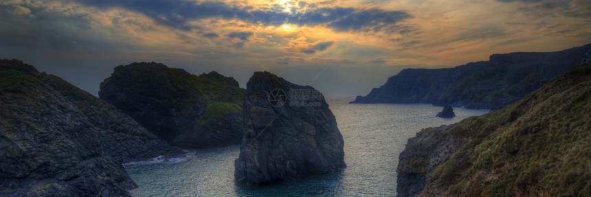 日落时岩石海岸线的全景景观图片
