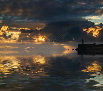美丽的日出海洋与灯塔港口墙图片