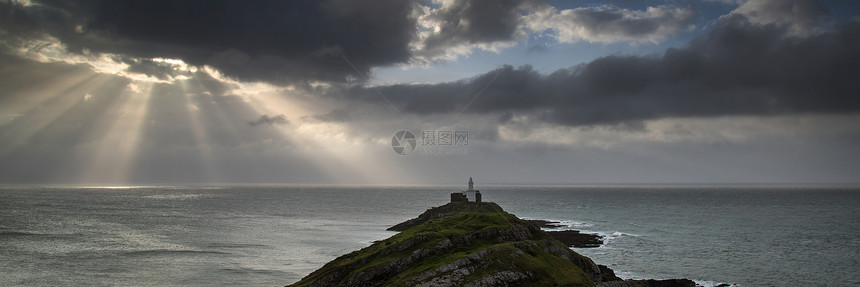 威尔士的莫布尔灯塔的景观全景,阳光照射海上图片