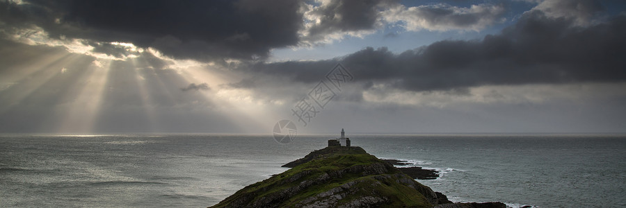 威尔士的莫布尔灯塔的景观全景,阳光照射海上高清图片