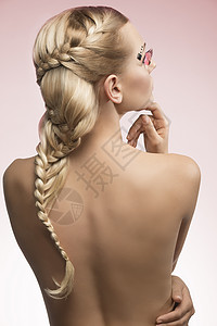 感的金发女人,可爱的长辫发型创造的羽毛化妆,她感的背部图片