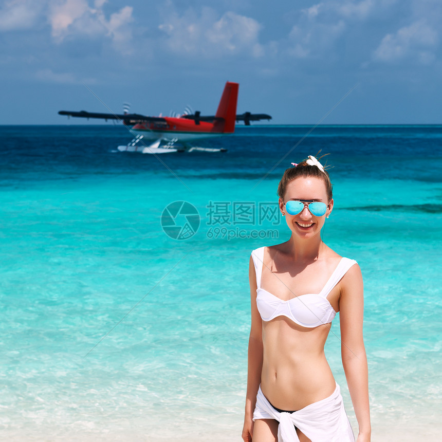 热带海滩穿比基尼的女人水上飞机后台图片