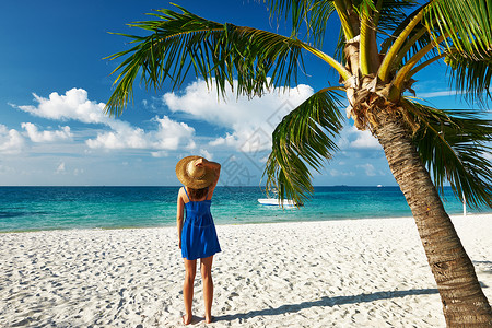 穿着蓝色连衣裙的女人马尔代夫的热带海滩上图片