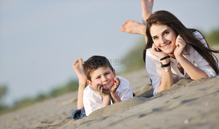 快乐的轻母亲儿子放松玩沙滩游戏夏天的季节图片