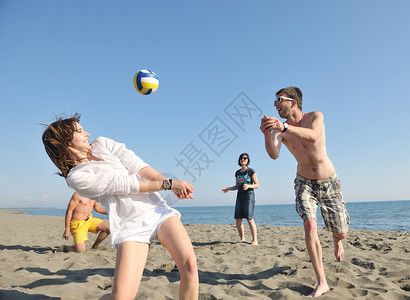 轻人体玩得开心,阳光明媚的夏日打沙滩排球高清图片