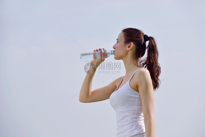 轻的美女健身运动户外慢跑后喝水图片