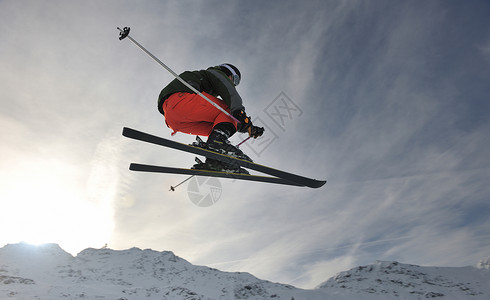 特技天空极限自由式滑雪跳跃与轻人山上的雪公园冬季季节背景