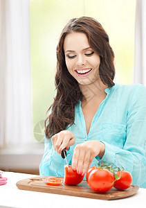 健康食品美丽的女人厨房切西红柿图片