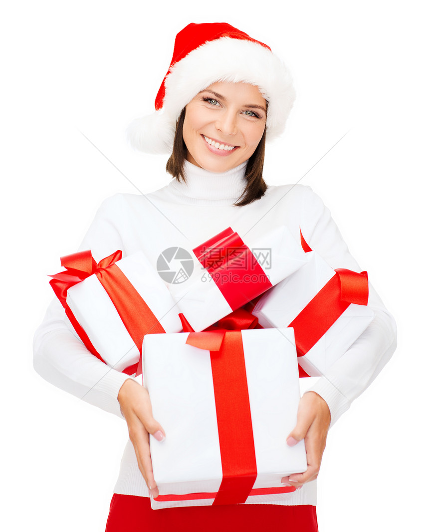 诞节,冬天,幸福的微笑的女人戴着诞老人的帽子,很多礼品盒图片
