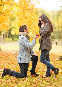 假期,爱情,夫妻,关系约会的跪着的男人秋天的公园向个女人求婚图片