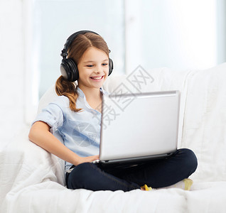 tif格式家庭,休闲,新技术音乐微笑的小女孩带着笔记本电脑耳机家背景