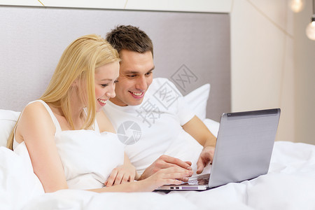 酒店,旅游,关系,技术,互联网幸福的微笑夫妇床上笔记本电脑背景图片