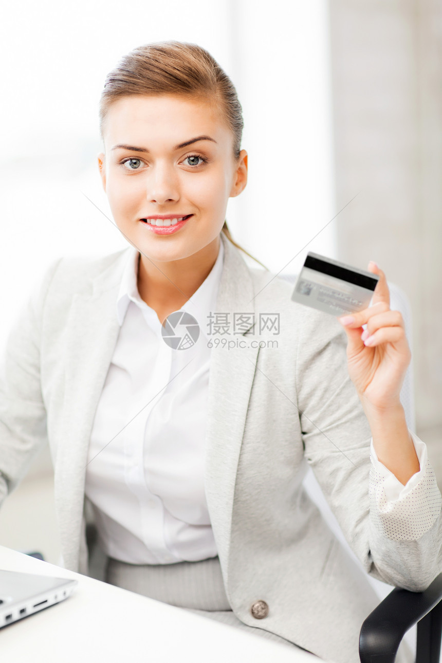 微笑的女商人带着笔记本电脑信用卡图片