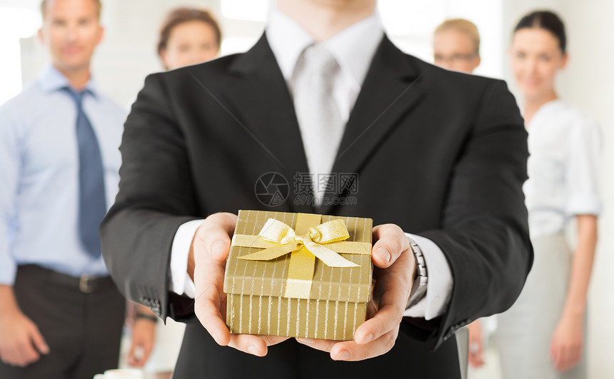 办公室里,紧握着礼品盒的人的手图片