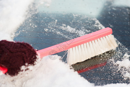 运输,冬季车辆特写妇女清理雪汽车后窗刷图片