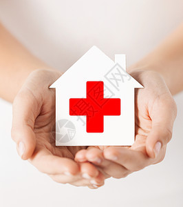 医疗保健医药慈善理念双手着带红十字标志的白纸屋背景