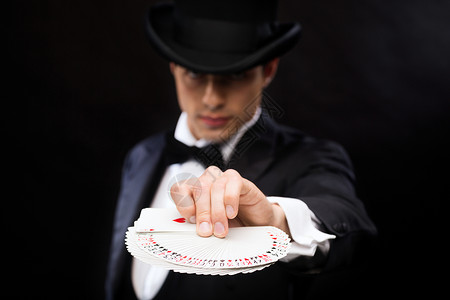 21载魔术,表演,马戏,赌场,扑克,表演魔术师戴着顶帽表演扑克牌背景