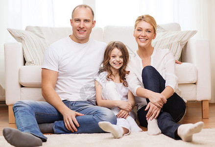 家庭,孩子家庭的微笑的父母小女孩坐家里的地板上图片