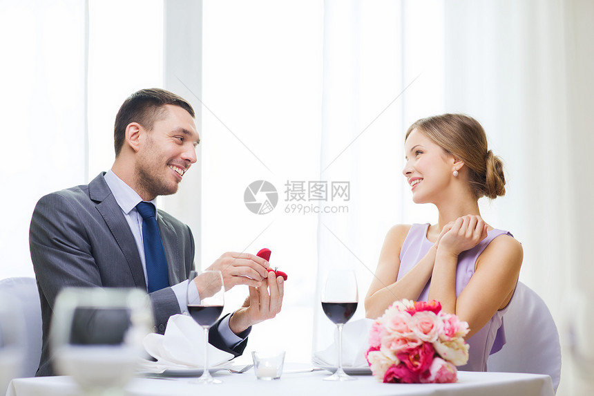 餐厅,情侣节日微笑的男人向他餐馆的女朋友求婚图片