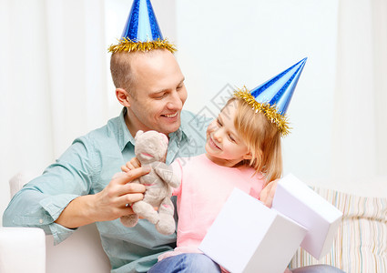 家庭,孩子,庆祝,节日,生日快乐的人的快乐的父亲女儿戴着蓝色的派帽礼品盒图片