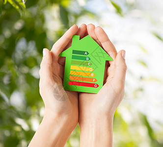 节能,房地产家庭住宅特写女手绿色纸房的能效评级图片