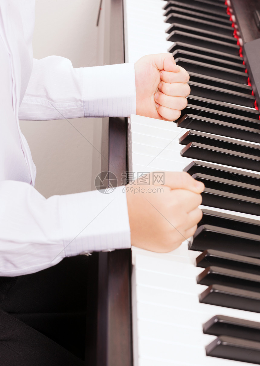 音乐乐器的把孩子的手收来,用拳头敲击钢琴图片